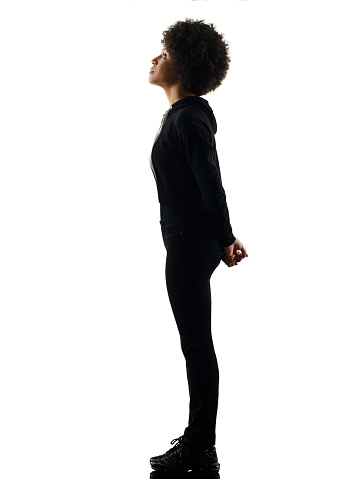 one mixed race african young teenager girl woman standing looking up in studio shadow silhouette isolated on white background