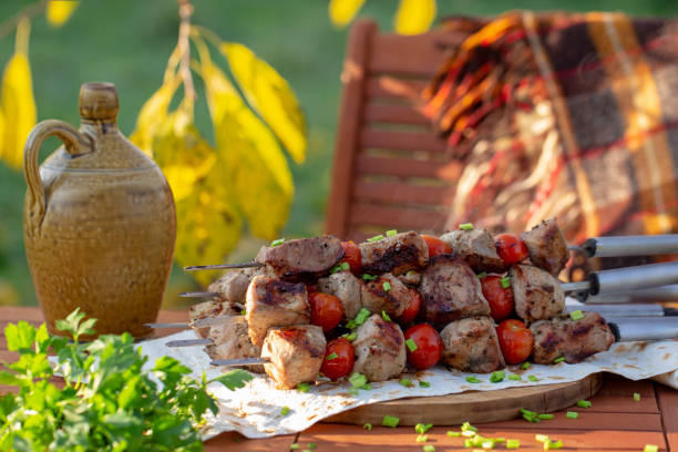 kebab with tomatoes on the table in the garden stock photo
