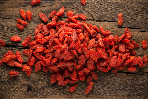 frutta secca di bacche di goji o wolfberry su tavolo rustico in legno - lycium chinese foto e immagini stock