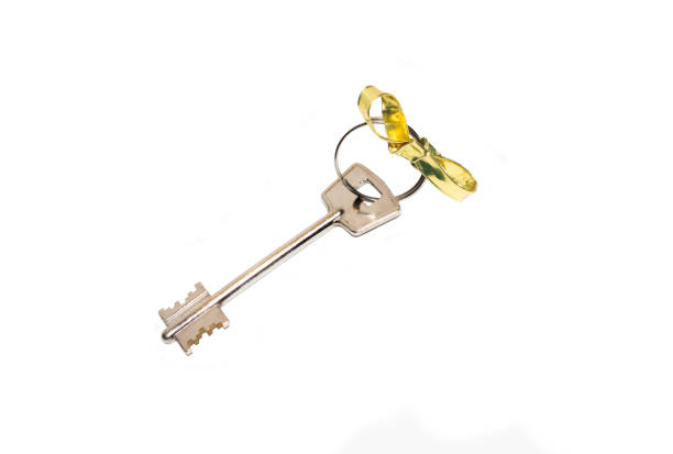 istock apartment key with gold bow on white isolated background 1065063816