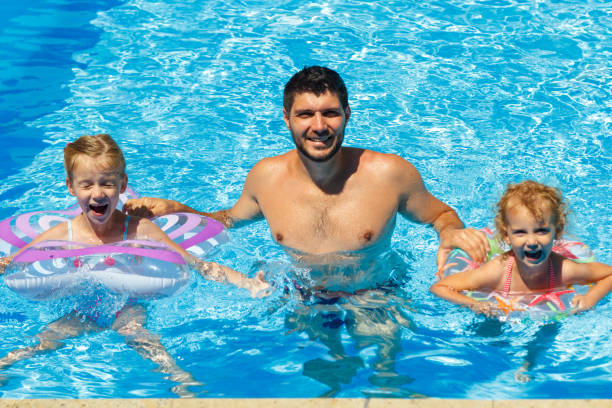 istock A man with two daughters in the outdoor pool. 1065068350