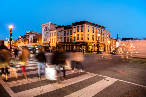 Motion blurred pedestrians crossing street at dusk in Georgetown, Washington District of Columbia, Amerika