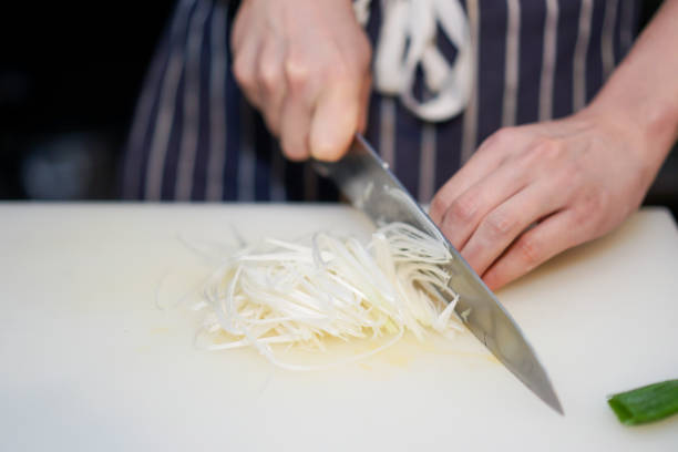 istock Sliced onion on the plastic chopping board by Asian chef's hand. 1065070298