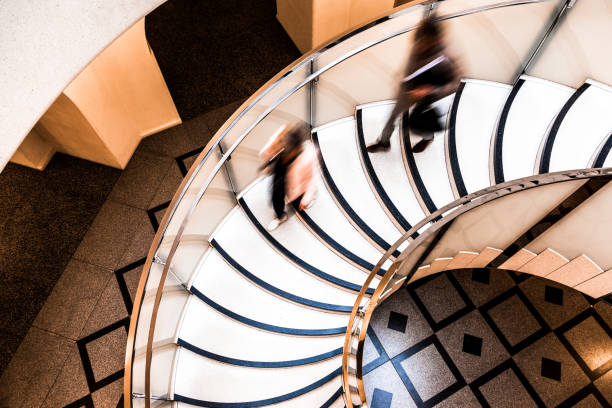istock Motion Blur of People on Abstract Spiral Staircase 1065079458