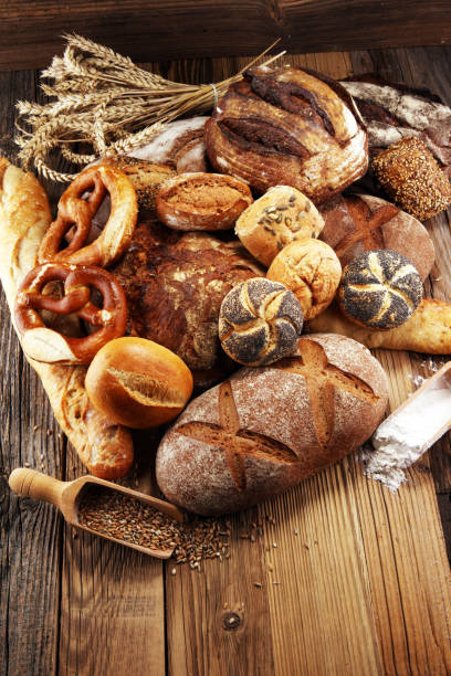 istock Different kinds of bread and bread rolls on board from above. Kitchen or bakery 1065084364