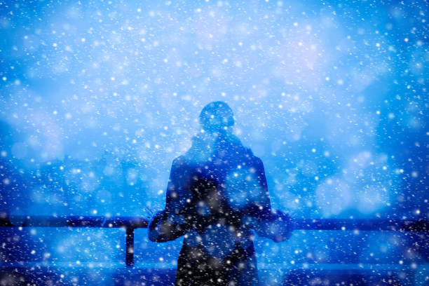 istock Young woman looking at view from balcony while snowing 1065085454