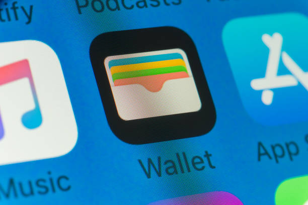 London, UK - August 01, 2018: The buttons of the Apple apps Wallet, App Store, Music and Spotify and Podcasts on the screen of an iPhone.