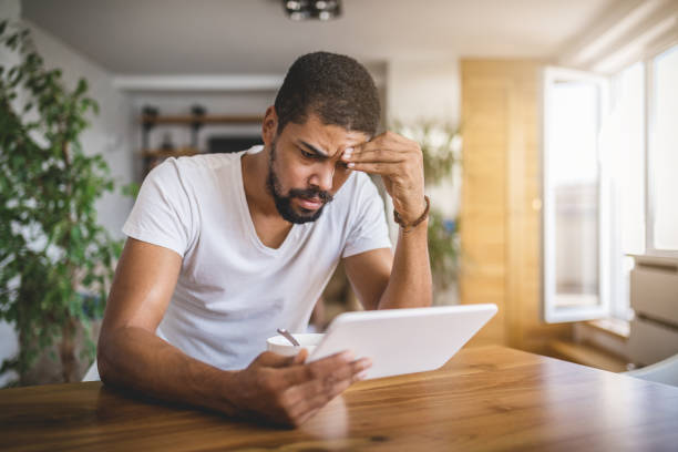 istock Worried man contemplating during breakfast looking at a digital tablet 1065097580