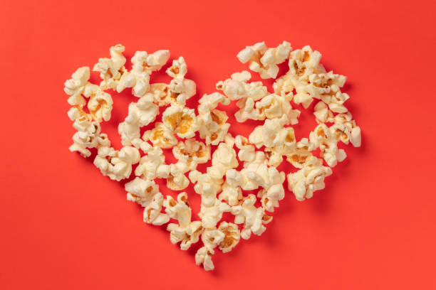 istock Heart shaped white fluffy popcorn on red background 1065099002