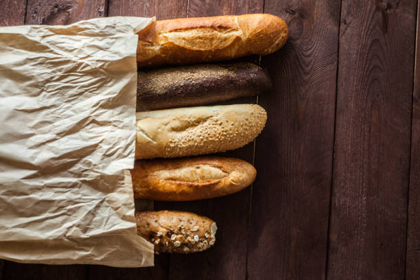 istock Various baked breads and baguettes on rustic wooden table. Close up 1065099020