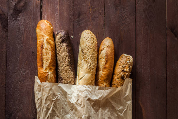 istock Various baked breads and baguettes on rustic wooden table. Close up 1065099022