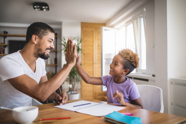 istock Father and daughter doing a high-five after completing a school homework 1065102488