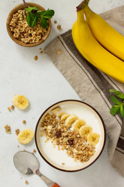 istock Granola. Granola with yogurt, chocolate and banana on a white stone table. 1065109420