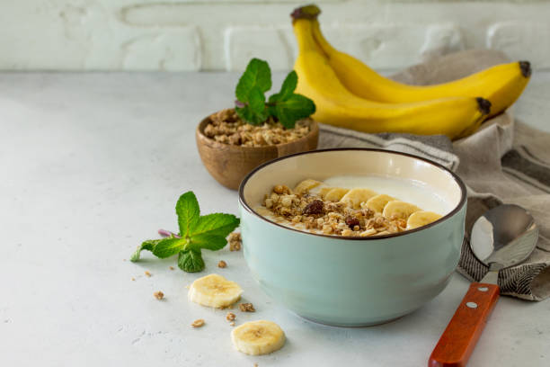 istock Granola. Granola with yogurt, chocolate and banana on a white stone table. 1065109434