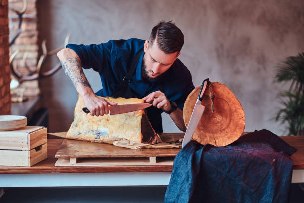 istock Chef cook cutting exclusive jerky meat on table in a kitchen with loft interior. 1065116342