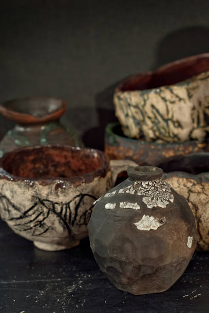istock Clay pottery and ceramic products on a black wooden table. Home workshop. Handmade with drawings and patterns. 1065119016