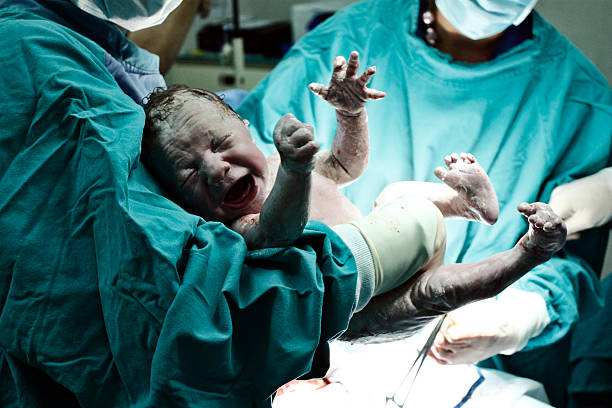 médecin tenant nouveau-né - cesarean photos et images de collection