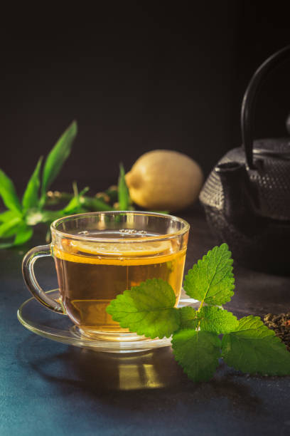 istock Cup with tea, mint and black teapot on dark background. Closeup. Chinese tea concept. 1065122190