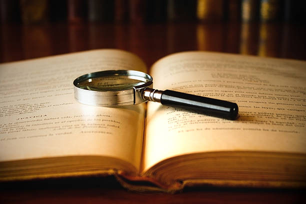istock Magnifying glass laid on the open pages of an old book 106512664