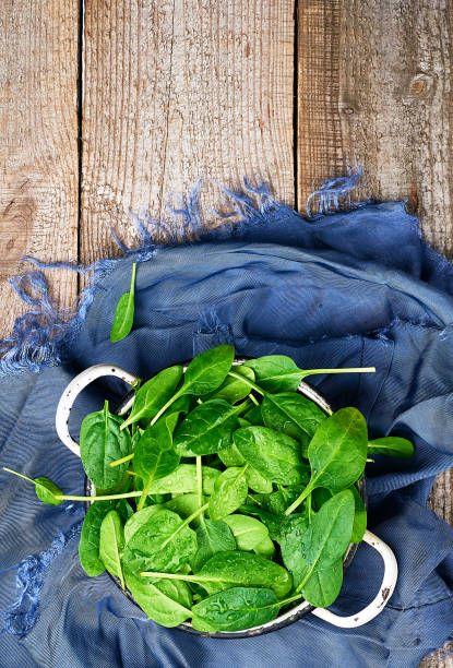 istock Fresh spinach leaves in a wooden background 1065127770