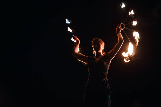 Circus girl spinning fire at night