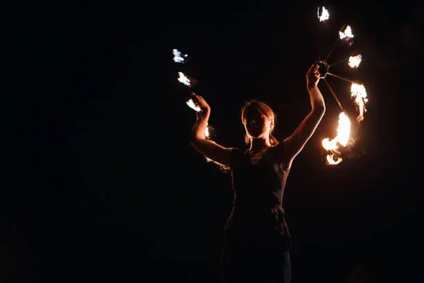 Photo of Circus girl spinning fire at night