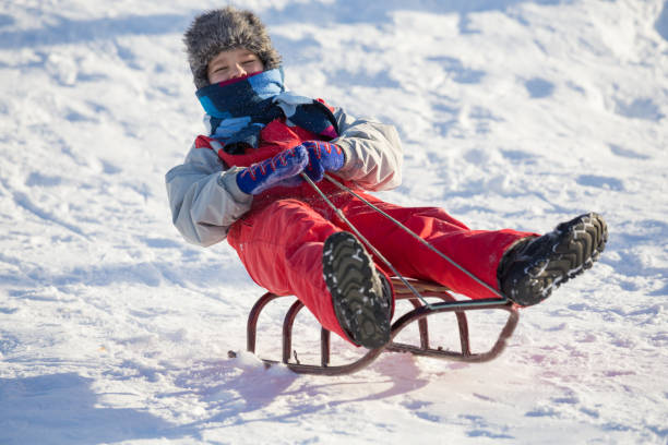 istock happy boy riding at the slide on snowy hill 1065147500