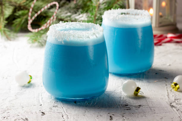 blue curacao christmas cocktail on christmas decorated holiday table - martini cocktail christmas blue imagens e fotografias de stock