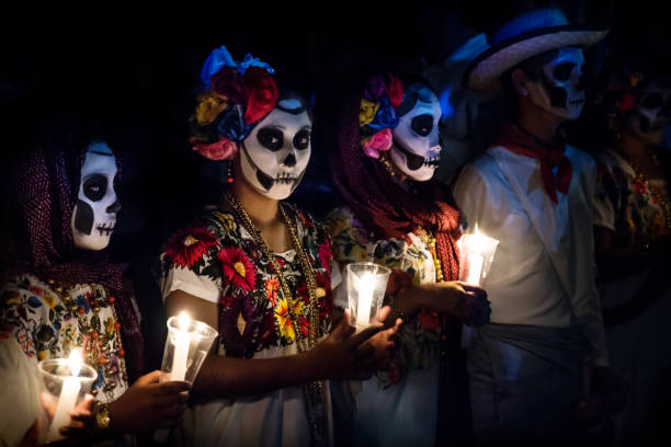tres mujeres con disfraces de catrina y hombre con vestido de vaquero blanco con cráneo velas de celebración de maquillaje en el desfile para los dias de los muertos en el festival de las ánimas en el cementerio general, mérida, méxico - dia de muertos fotografías e imágenes de stock