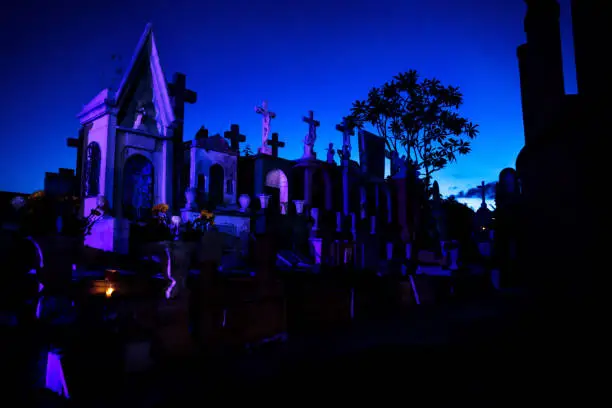 Photo of Blue and pink lightened tombstones during dawn in Cementerio General in Merida, Mexico