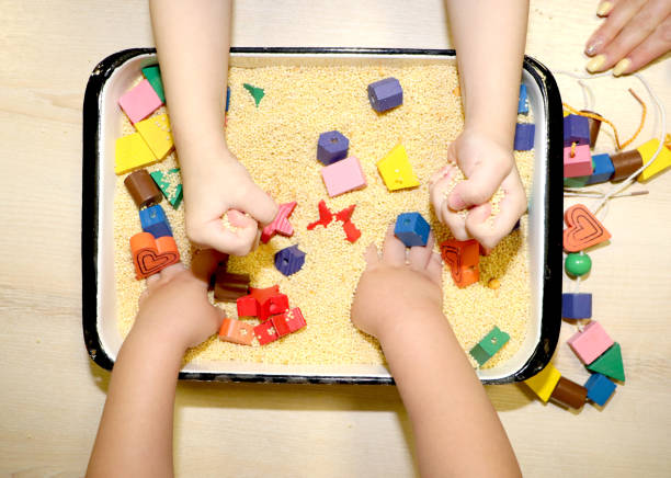 children playing with kinetic sand, croup and designer in preschool. the development of fine motor concept. creativity game concept. - sandbox child human hand sand imagens e fotografias de stock