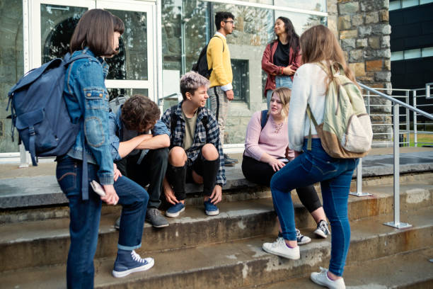 istock Multi-ethnic group of students taking a break in front of College doors. 1065166034