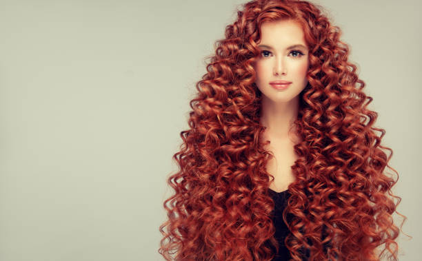 Portrait of young, attractive young model with incredible dense, long, curly red hair.Frizzy hair. stock photo