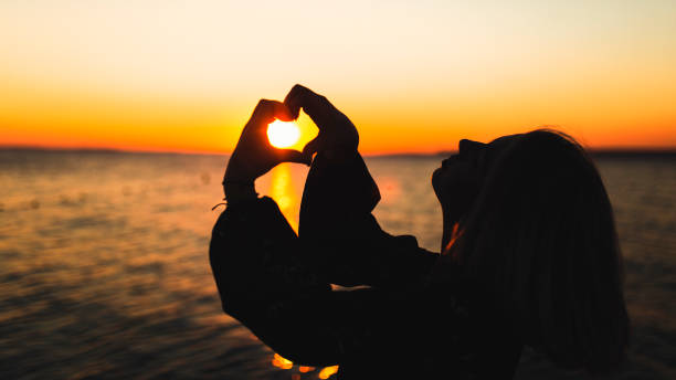 istock happy women sunset heart 1065166794