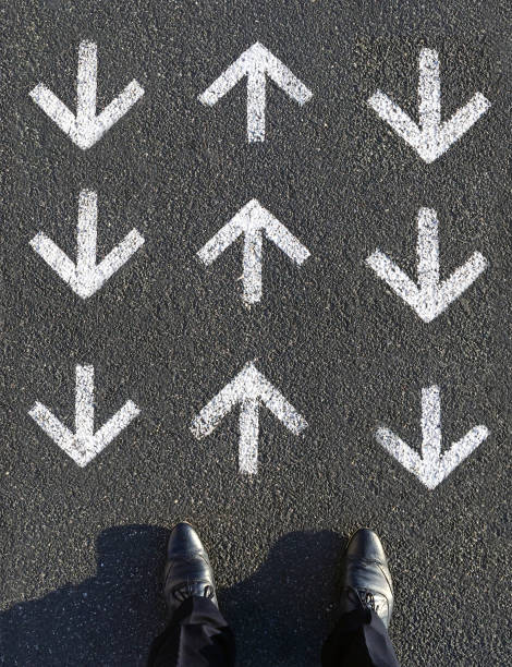 istock Finding the way forward: A man standing in front of arrow signs 1065167198