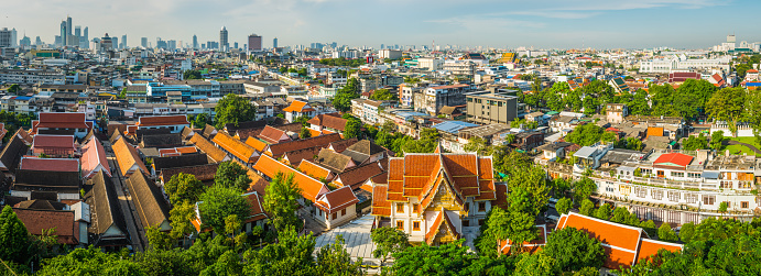 Panoramic view over the terracotta rooftops of Wat Saket temple complex to the crowded cityscape of central Bangkok, Thailand’s vibrant capital city.