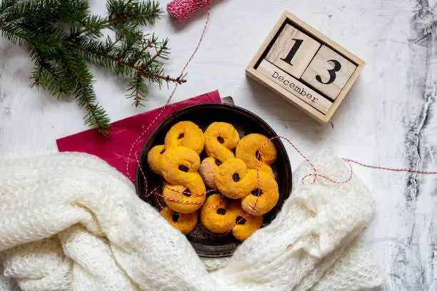 Photo of Swedish christmas. Gluten free version Traditional swedish buns in christmas setting. A saffron bun, in Swedish lussebulle or lussekatt.