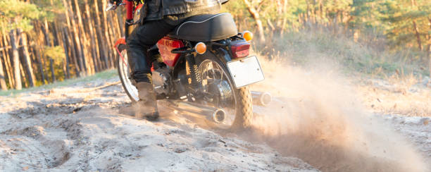istock Biker rides on a sandy road in the woods. 1065174980