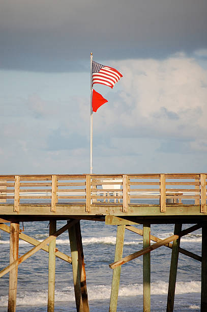 Storm clouds and flags on Pier stock photo
