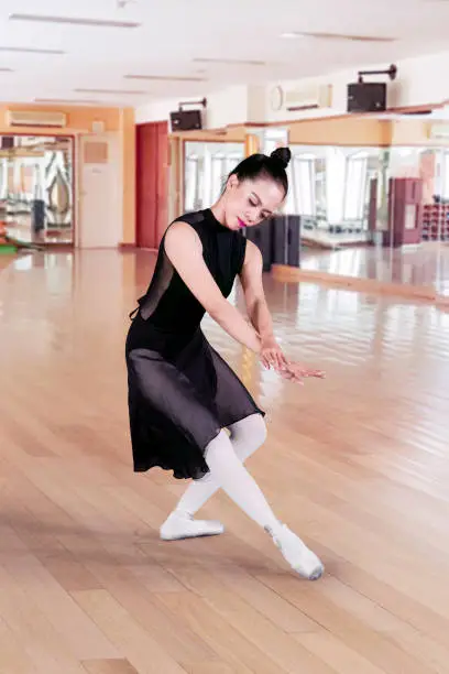 Portrait of Asian woman wearing black tutu while performing dances in the ballet class