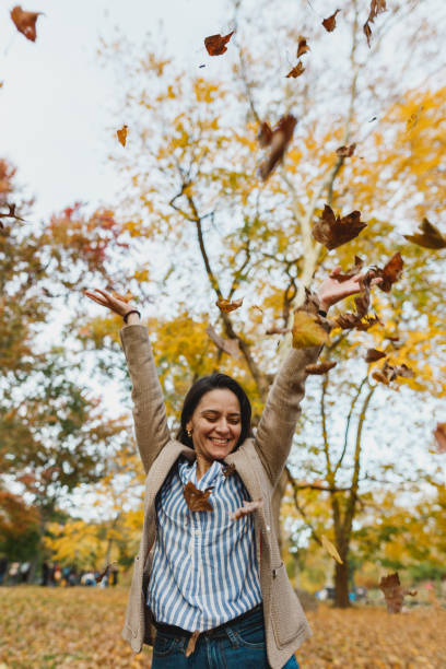 istock Woman throwing autumn leaves in Central Park 1065175764