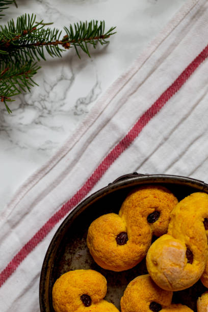 schwedische weihnachten. gluten freie version traditionelle schwedische brötchen in weihnachten einstellung. ein safran brötchen im schwedischen lussebulle oder lussekatt. - lucia bun stock-fotos und bilder