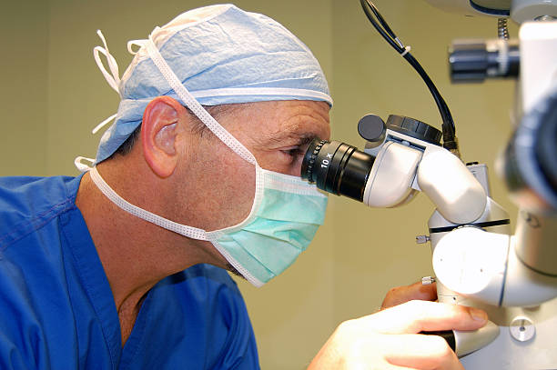 Surgeon using operating microscope stock photo