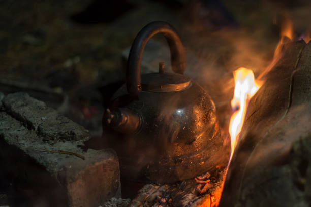 la caldera se calienta sobre un fuego por la noche al aire libre - reclusion fotografías e imágenes de stock