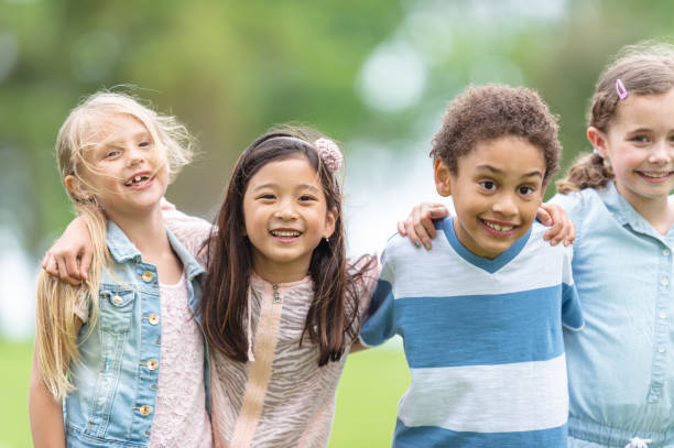 istock Children with their arms around each other at a park 1065178994
