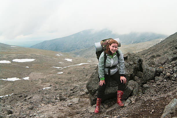 istock Backpacker a young woman sitting on rock in mountains 106517932
