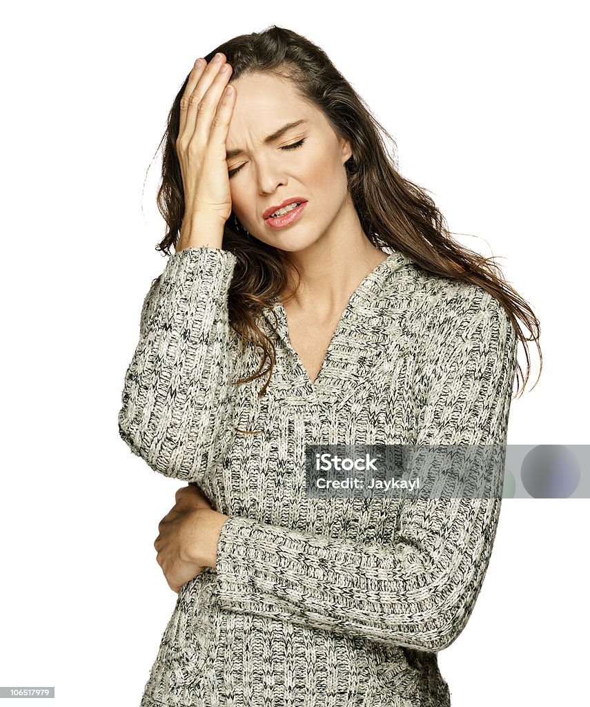 A young, brunette woman suffers from a headache A young attractive woman suffering from illness or headache holding her head. Isolated on white. Adult Stock Photo