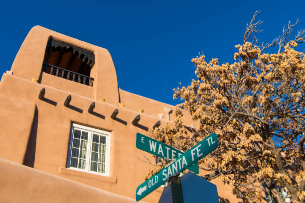 cartello stradale per lo storico old santa fe trail e l'edificio in adobe in stile pueblo a santa fe, nuovo messico - santa fe trail foto e immagini stock