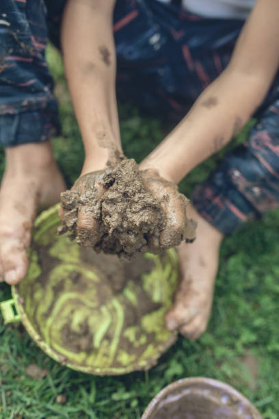 istock Retro image of toddler boy exploring nature playing with mud 1065183910