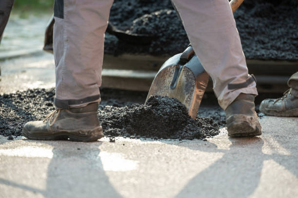 istock Closeup low angle view of worker arranging fresh asphalt mixture 1065184554